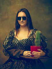 Image showing Young woman as Mona Lisa on dark background. Retro style, comparison of eras concept.