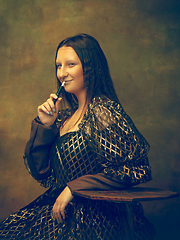 Image showing Young woman as Mona Lisa on dark background. Retro style, comparison of eras concept.