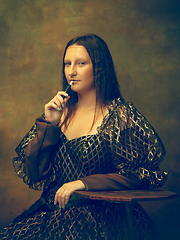 Image showing Young woman as Mona Lisa on dark background. Retro style, comparison of eras concept.