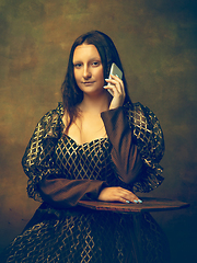 Image showing Young woman as Mona Lisa on dark background. Retro style, comparison of eras concept.