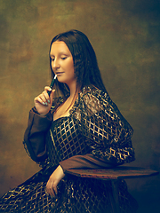 Image showing Young woman as Mona Lisa on dark background. Retro style, comparison of eras concept.