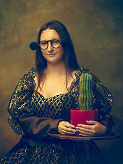 Image showing Young woman as Mona Lisa on dark background. Retro style, comparison of eras concept.