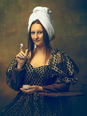 Image showing Young woman as Mona Lisa on dark background. Retro style, comparison of eras concept.