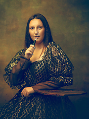 Image showing Young woman as Mona Lisa on dark background. Retro style, comparison of eras concept.