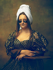 Image showing Young woman as Mona Lisa on dark background. Retro style, comparison of eras concept.