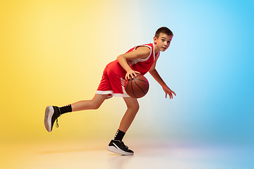 Image showing Full length portrait of a young basketball player with ball on gradient background