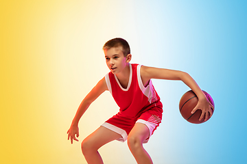 Image showing Full length portrait of a young basketball player with ball on gradient background