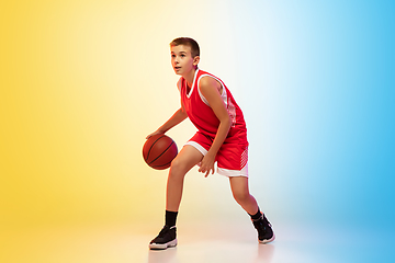 Image showing Full length portrait of a young basketball player with ball on gradient background