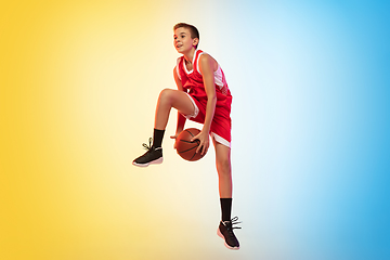 Image showing Full length portrait of a young basketball player with ball on gradient background