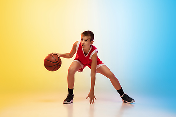 Image showing Full length portrait of a young basketball player with ball on gradient background