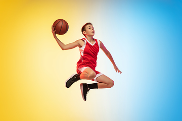 Image showing Full length portrait of a young basketball player with ball on gradient background