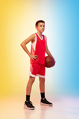 Image showing Full length portrait of a young basketball player with ball on gradient background