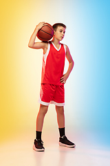 Image showing Full length portrait of a young basketball player with ball on gradient background