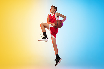 Image showing Full length portrait of a young basketball player with ball on gradient background