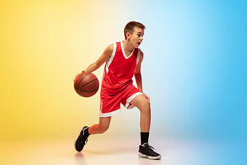 Image showing Full length portrait of a young basketball player with ball on gradient background