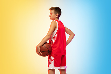 Image showing Full length portrait of a young basketball player with ball on gradient background