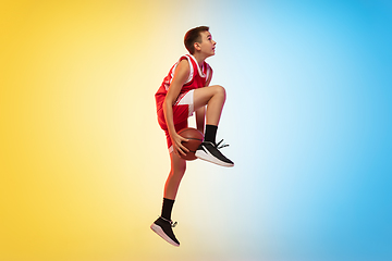 Image showing Full length portrait of a young basketball player with ball on gradient background