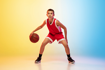 Image showing Full length portrait of a young basketball player with ball on gradient background