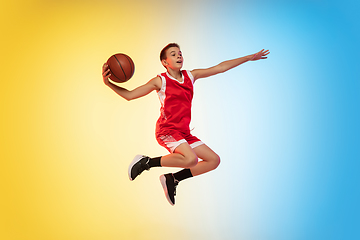 Image showing Full length portrait of a young basketball player with ball on gradient background