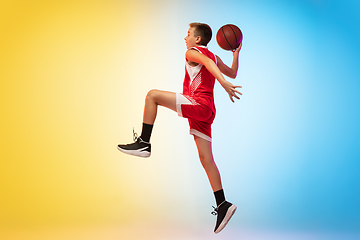 Image showing Full length portrait of a young basketball player with ball on gradient background