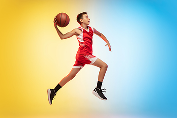 Image showing Full length portrait of a young basketball player with ball on gradient background