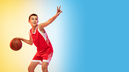 Image showing Full length portrait of a young basketball player with ball on gradient background