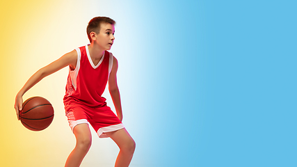 Image showing Full length portrait of a young basketball player with ball on gradient background