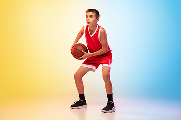 Image showing Full length portrait of a young basketball player with ball on gradient background