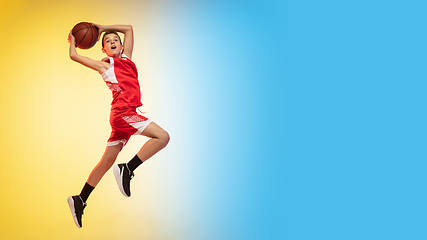 Image showing Full length portrait of a young basketball player with ball on gradient background