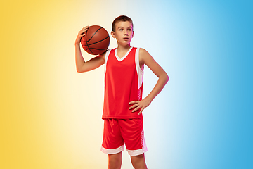 Image showing Full length portrait of a young basketball player with ball on gradient background