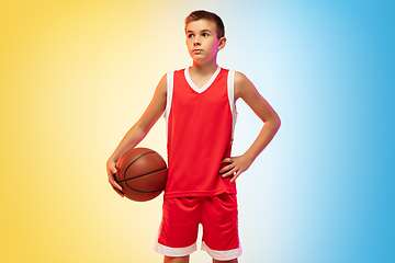 Image showing Full length portrait of a young basketball player with ball on gradient background