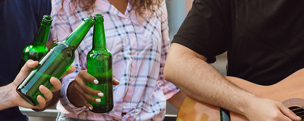 Image showing Hands of young friends, colleagues during beer drinking, having fun, laughting and celebrating together. Flyer with copyspace