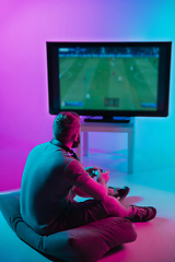 Image showing Back view shot of professional gamer playing online video game on his personal computer.