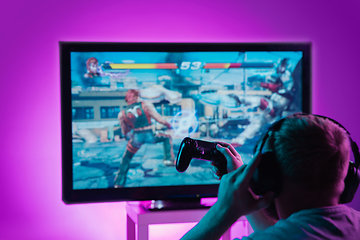 Image showing Back view shot of professional gamer playing online video game on his personal computer.