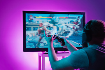 Image showing Back view shot of professional gamer playing online video game on his personal computer.