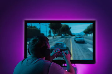 Image showing Back view shot of professional gamer playing online video game on his personal computer.