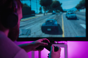 Image showing Back view shot of professional gamer playing online video game on his personal computer.