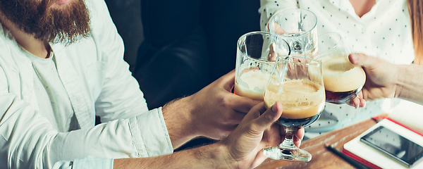 Image showing Hands of young friends, colleagues during beer drinking, having fun, laughting and celebrating together. Flyer with copyspace