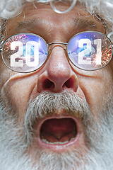 Image showing Close up Santa Claus in glasses with a reflection of 2021 Happy New Year