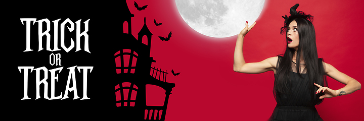 Image showing Young woman in hat as a witch on scary red background