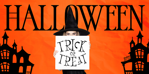 Image showing Young woman in hat as a witch on scary orange background