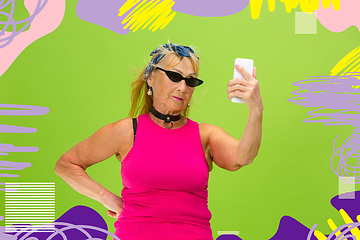 Image showing Senior hipster woman using devices, gadgets. Tech and joyful elderly lifestyle concept. Bright illustrated background