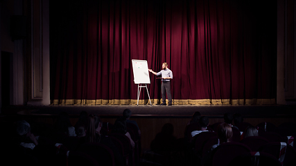 Image showing Male caucasian speaker giving presentation in hall at university or business centre workshop