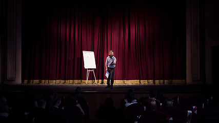 Image showing Male caucasian speaker giving presentation in hall at university or business centre workshop