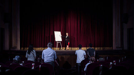 Image showing Female caucasian speaker giving presentation in hall at university or business centre workshop