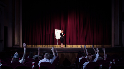 Image showing Female caucasian speaker giving presentation in hall at university or business centre workshop