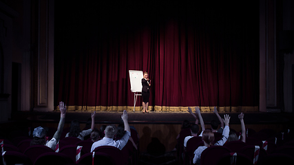 Image showing Female caucasian speaker giving presentation in hall at university or business centre workshop