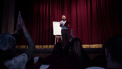 Image showing Male caucasian speaker giving presentation in hall at university or business centre workshop