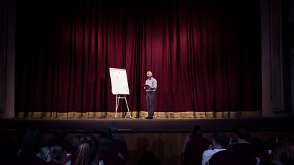 Image showing Male caucasian speaker giving presentation in hall at university or business centre workshop