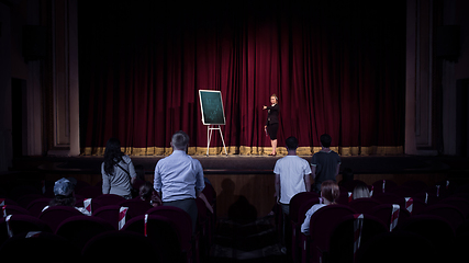 Image showing Female caucasian speaker giving presentation in hall at university or business centre workshop